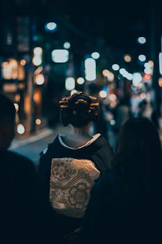 A geisha walks through Kyoto's night streets, showcasing traditional Japanese culture.
