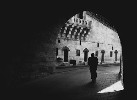 Black and white silhouette of a person walking through an archway in Istanbul.
