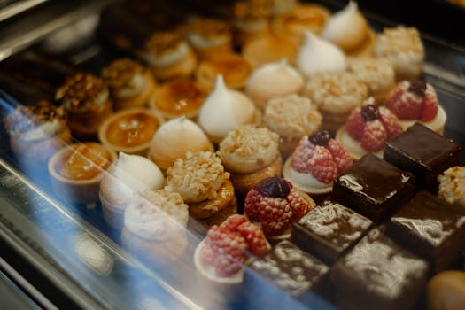 A delectable assortment of French pastries, tarts, and chocolates on display in a bakery setting.