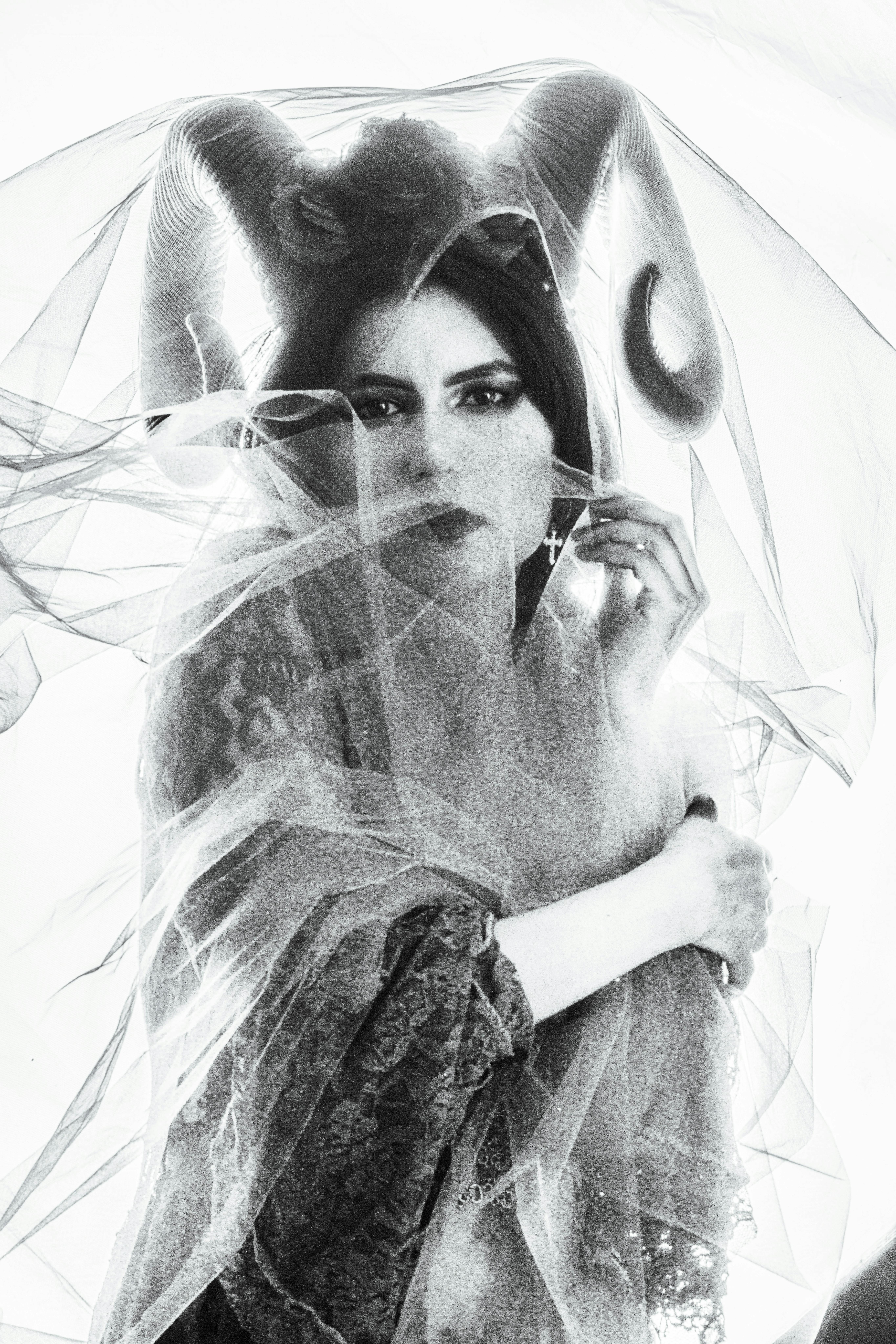 Gratuit Charmant portrait en noir et blanc d'une femme avec des cornes et un voile, évoquant le mysticisme. Photos