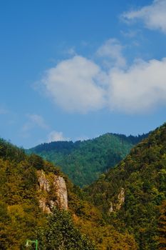 Breathtaking view of green mountains and blue sky, perfect for nature displays.