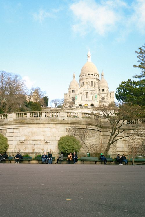 Free Stunning view of Sacre-Cœur Basilica in Paris with people relaxing under a clear blue sky. Stock Photo