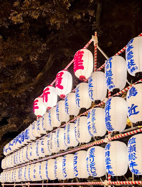 Free Elegant row of illuminated Japanese paper lanterns during a cultural night festival. Stock Photo