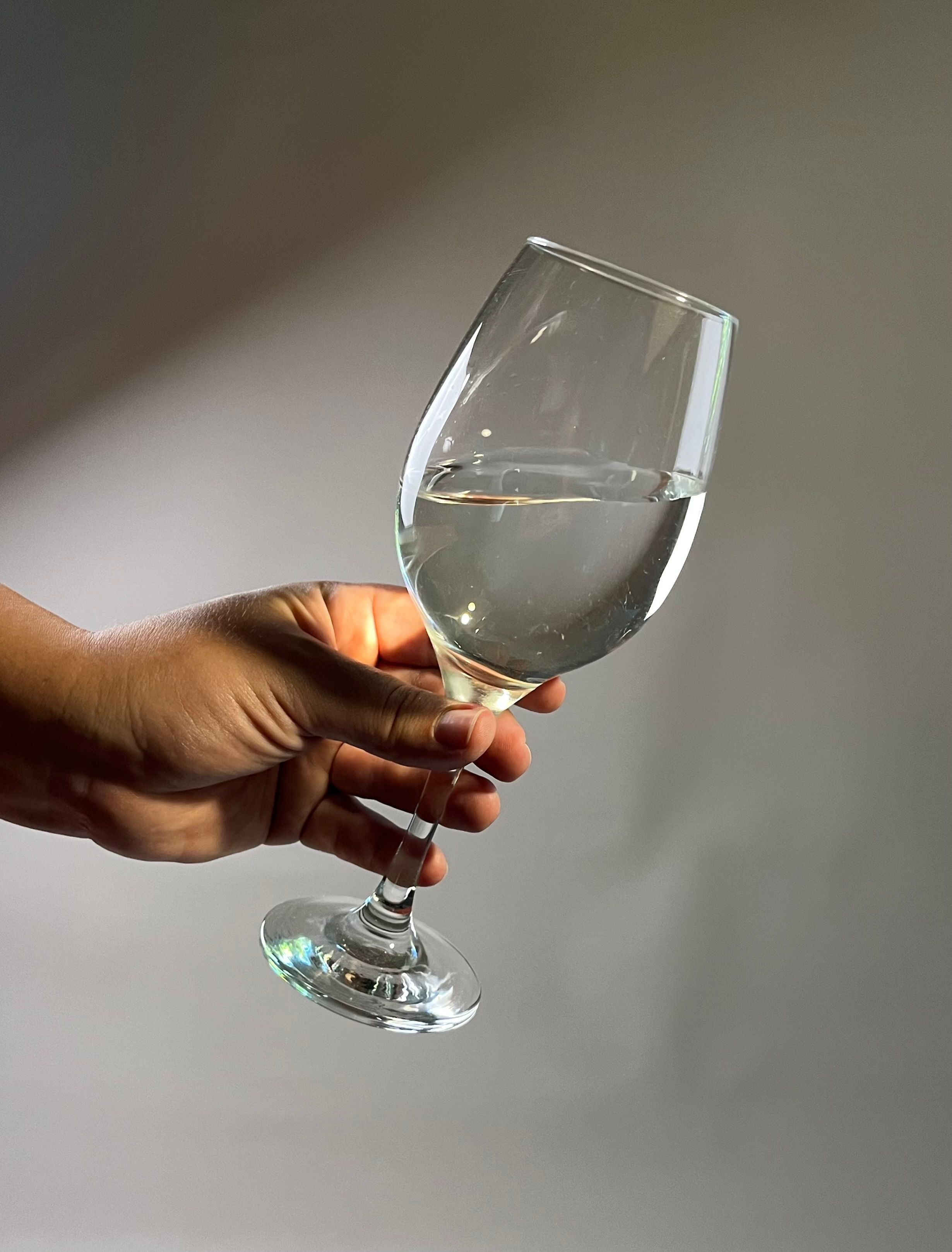 A woman in a black dress holding a glass of wine · Free Stock Photo