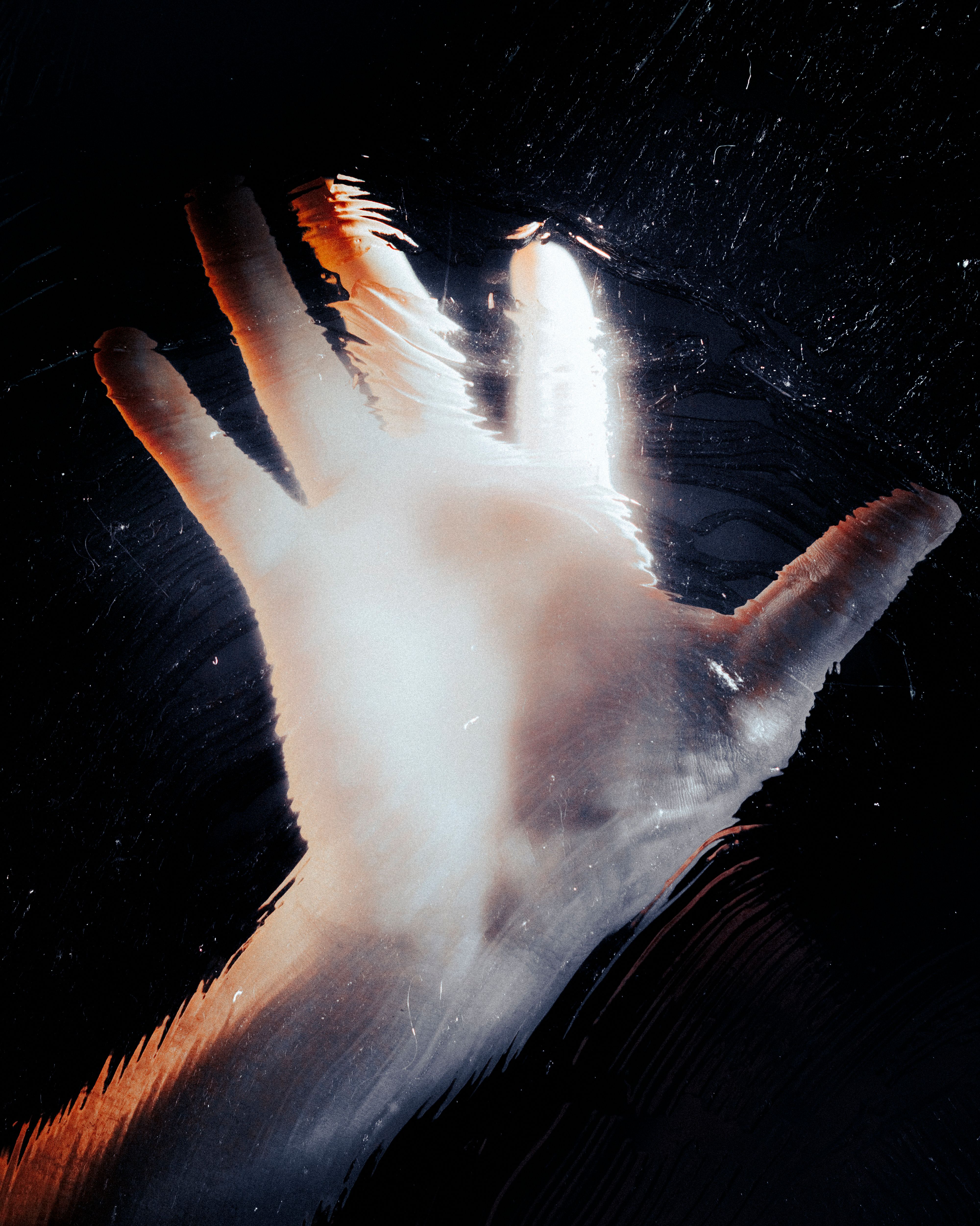 Hand Pressed Against Frosted Glass in Dark Setting · Free Stock Photo