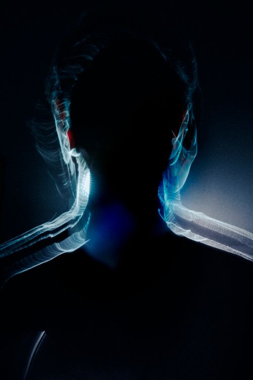Free Silhouette of a person with dynamic light trails in a dark setting. Stock Photo