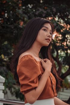 一位穿着休闲服装的年轻女子在自然背景下的时尚户外肖像