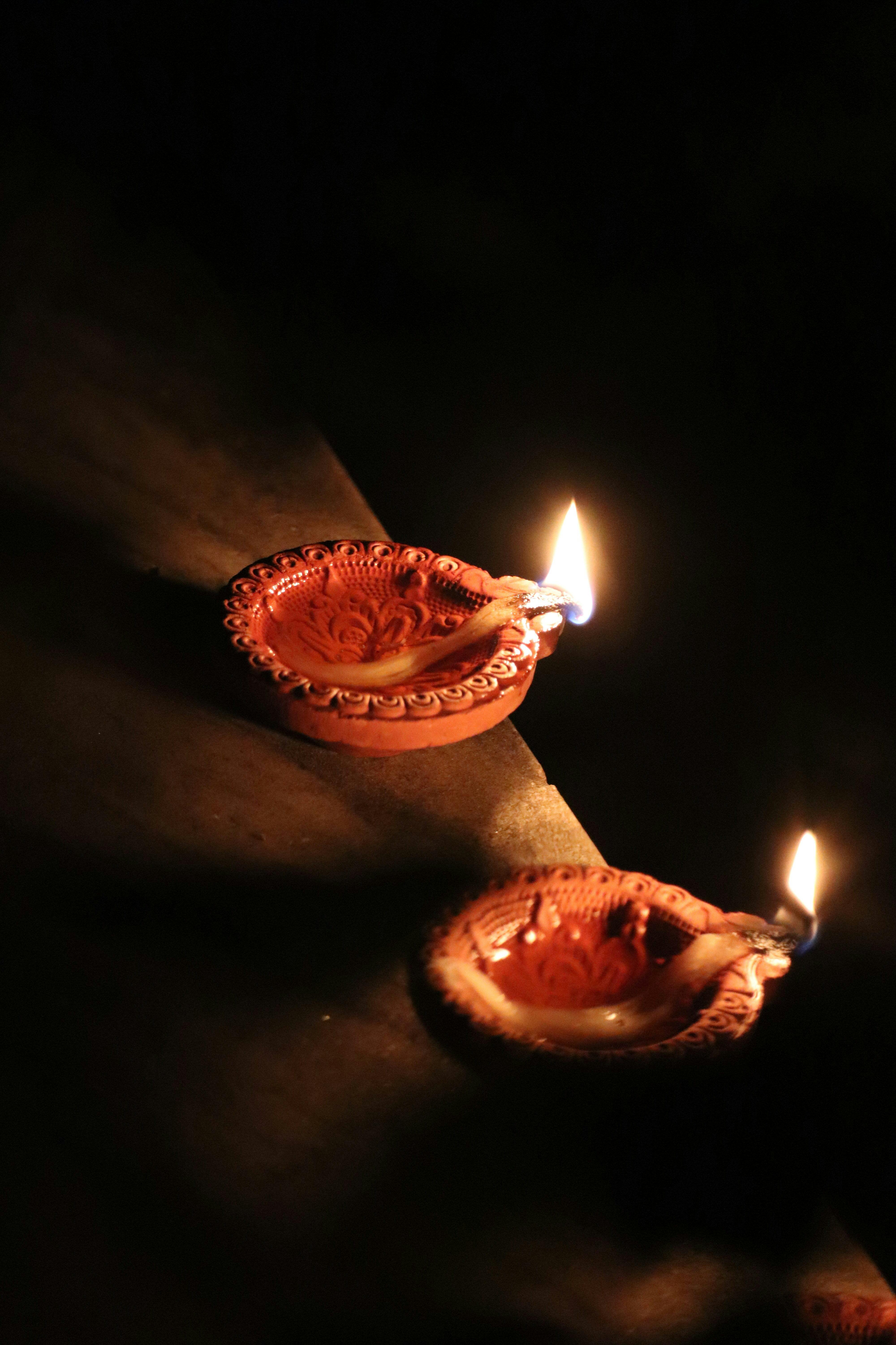 Clay diyas with flickering flames during Diwali celebration