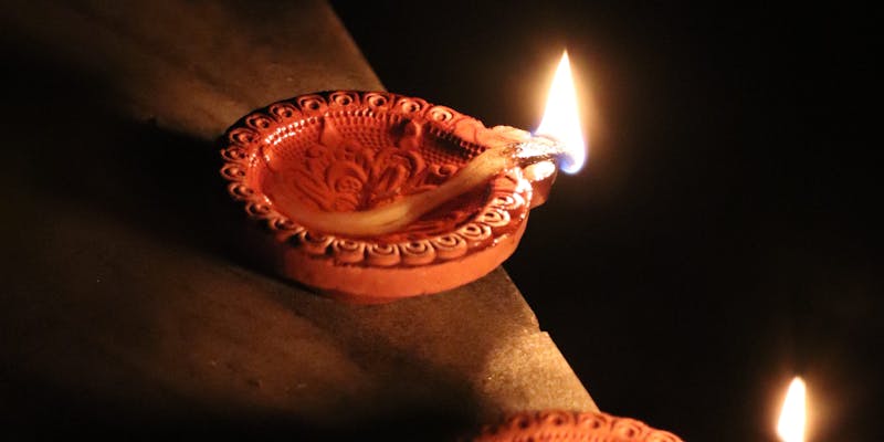 Clay diyas with flickering flames during Diwali celebration