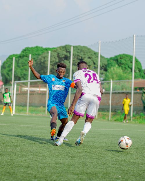 Free Players engaging in an exciting soccer match on a sunny outdoor field. Stock Photo
