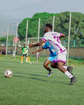 Soccer players in action during a match on a green field, showcasing competitive sports spirit.