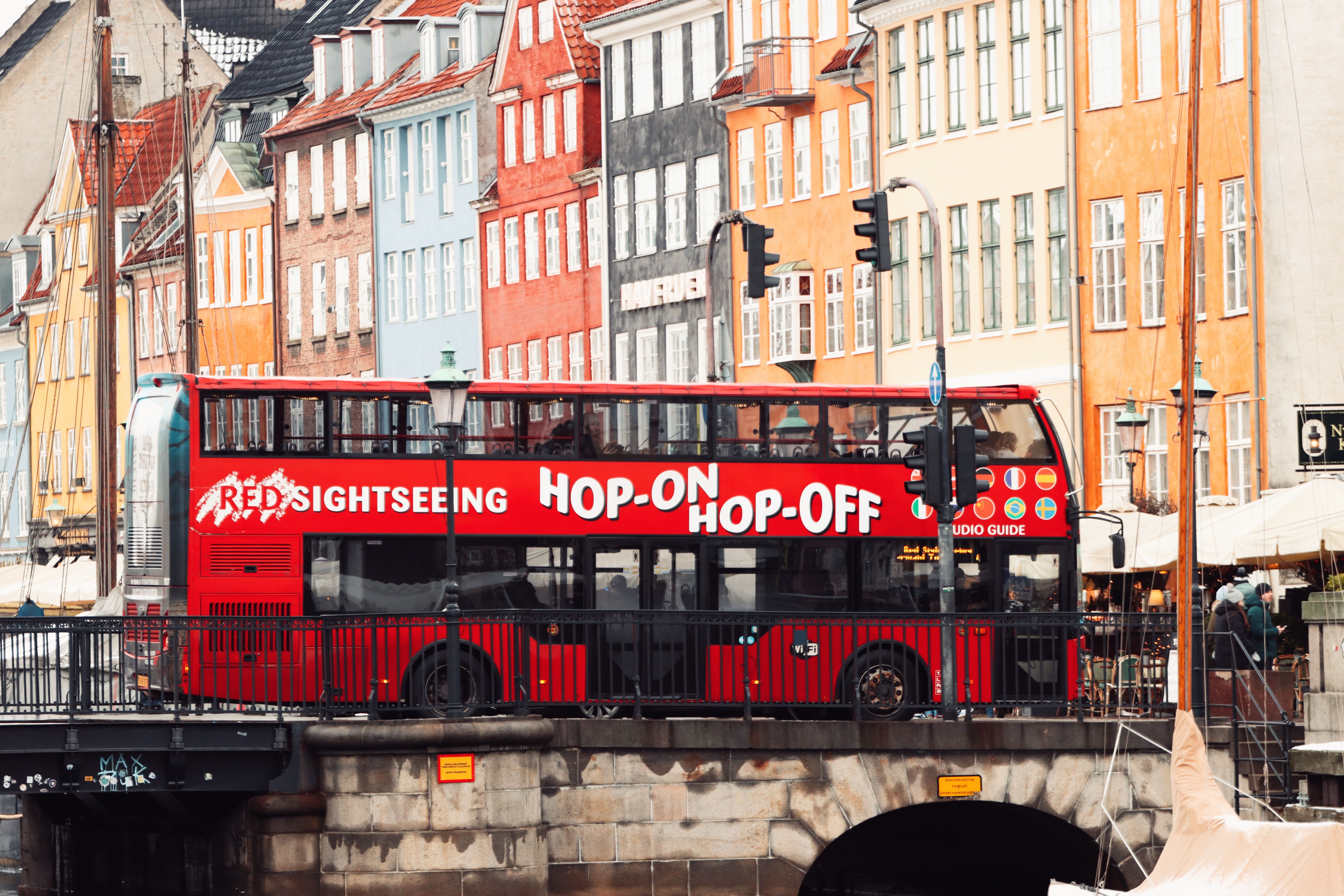 Colorful Nyhavn canal and red sightseeing bus in Copenhagen, Denmark.