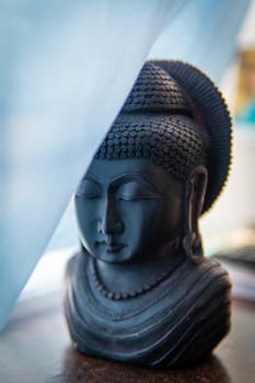 Close-up of a tranquil Buddha sculpture bathed in gentle blue light, capturing a sense of peace.
