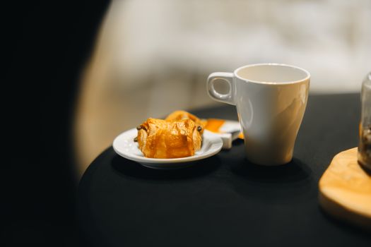 A warm breakfast scene featuring a coffee cup and pastry for a cozy start to the day.