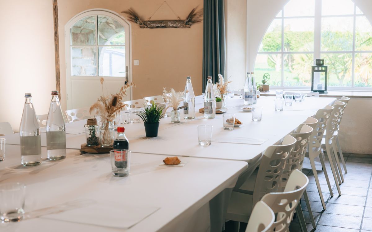 A beautifully set conference room with natural sunlight, water bottles, and minimal decor.