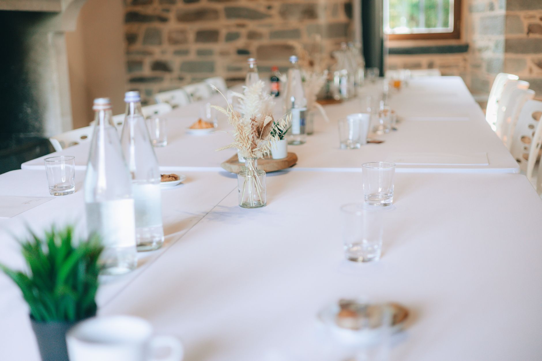 A refined table setup featuring bottled water, glasses, and decor in a stylish room.