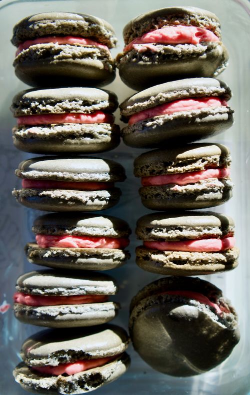 Free Tasty chocolate macarons with vibrant pink filling, perfect for dessert lovers. Stock Photo