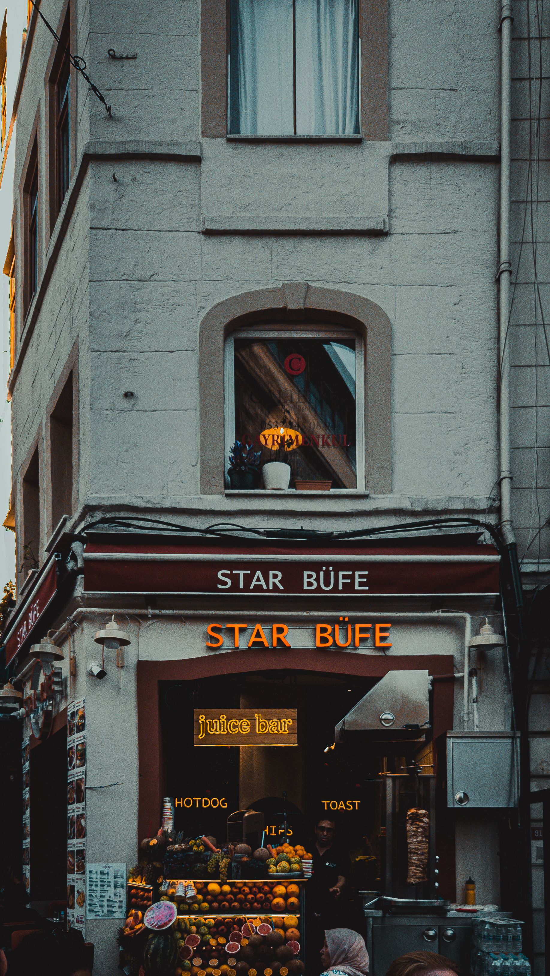 A quaint cafe and juice bar on a bustling street corner, offering fresh produce.
