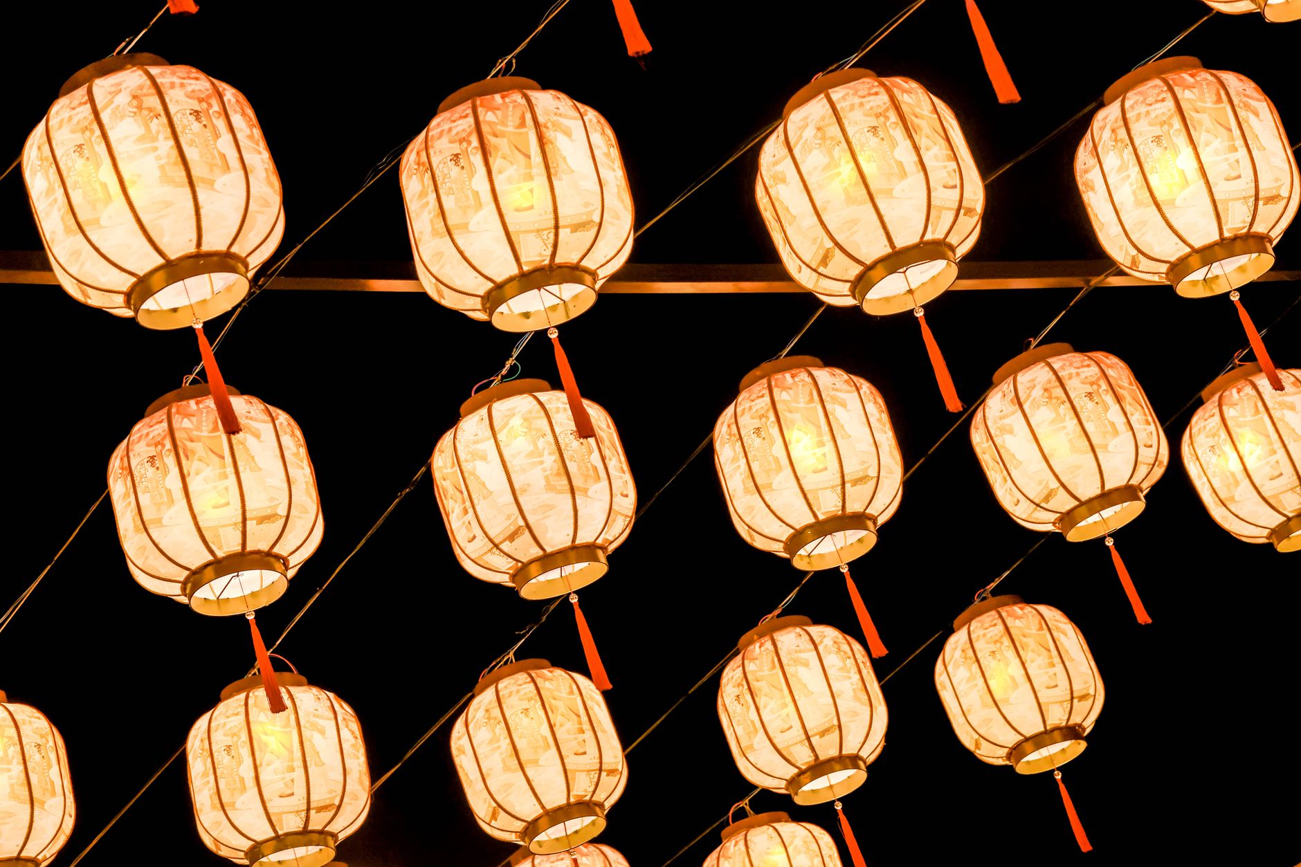 Traditional Chinese lanterns illuminated against a dark night backdrop, creating a festive ambiance.