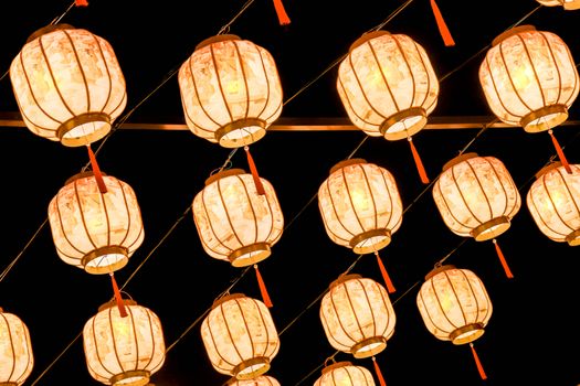 Traditional Chinese lanterns illuminated against a dark night backdrop, creating a festive ambiance.