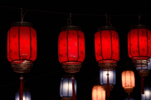 Vibrant red Chinese lanterns illuminated against a dark night backdrop.
