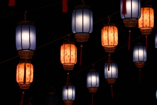 Vibrant Asian lanterns glowing against a dark night sky, perfect for cultural festivities.