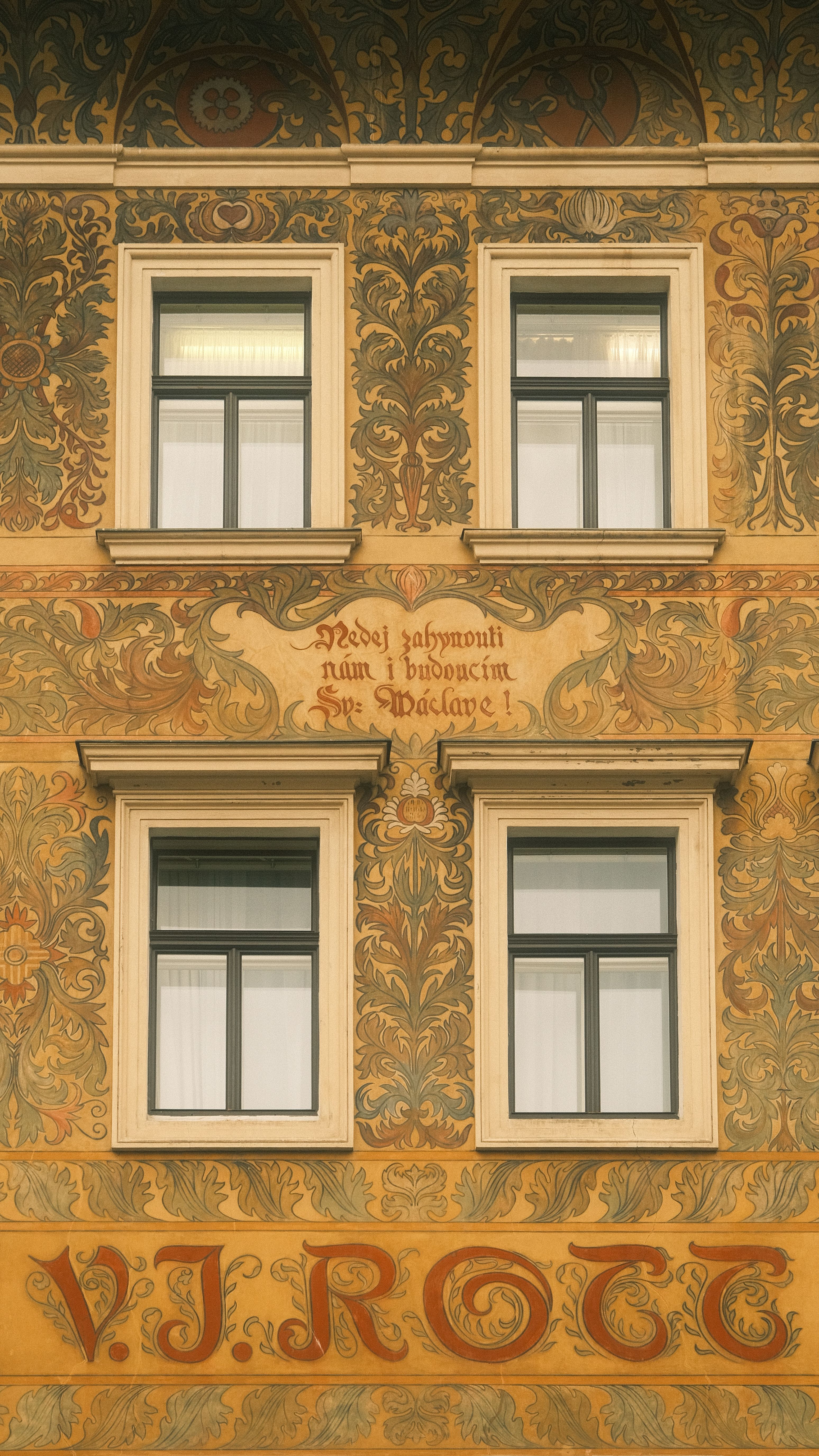 Detailed exterior facade of a historic European building with ornate design and vintage style windows.
