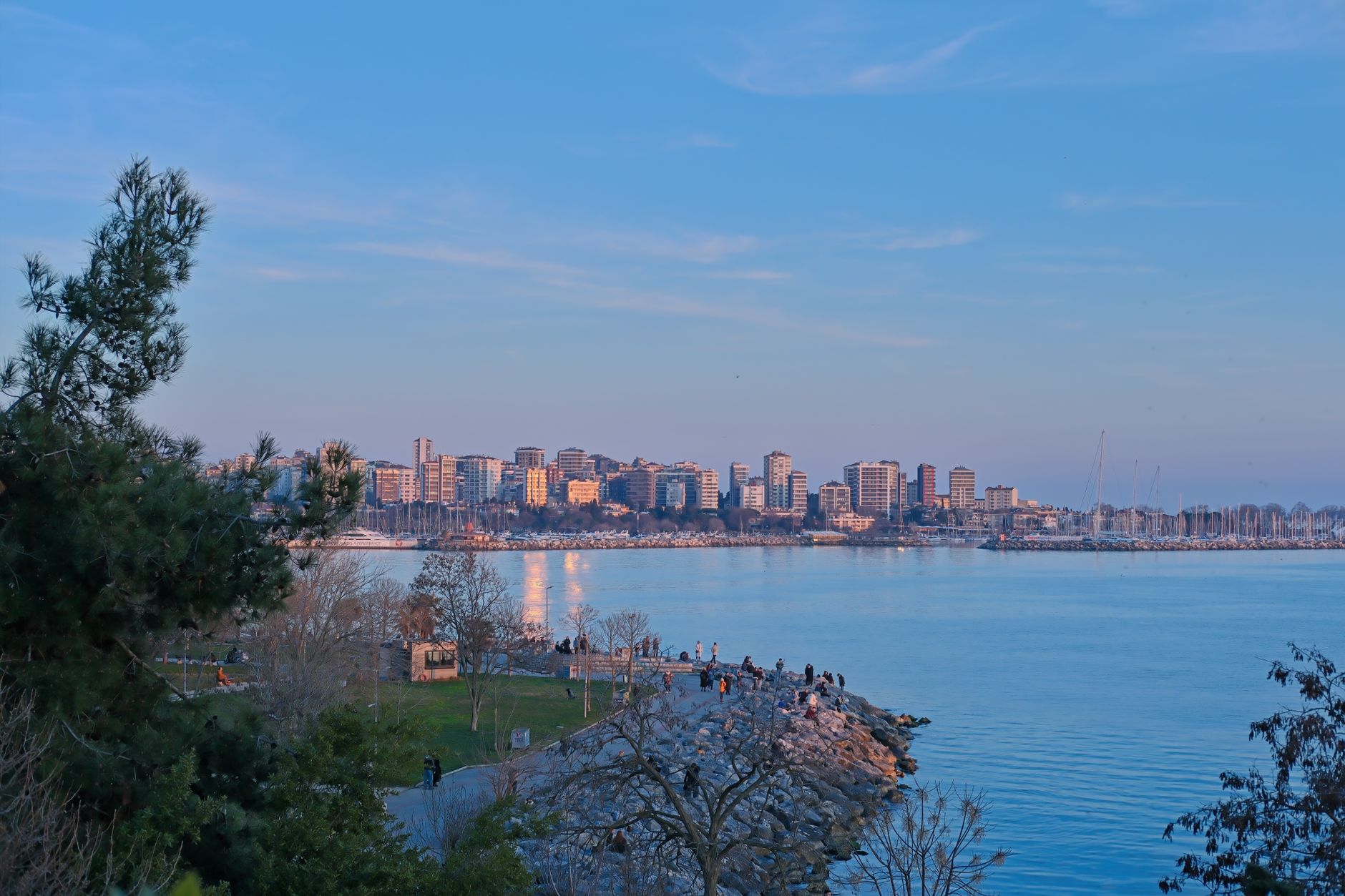 Discover the serene evening scene of Istanbul's seaside skyline with calm blue waters.