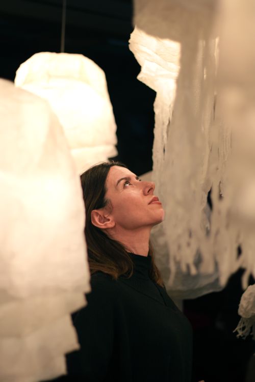 Free Woman gazing upwards amid an abstract paper art installation indoors. Stock Photo