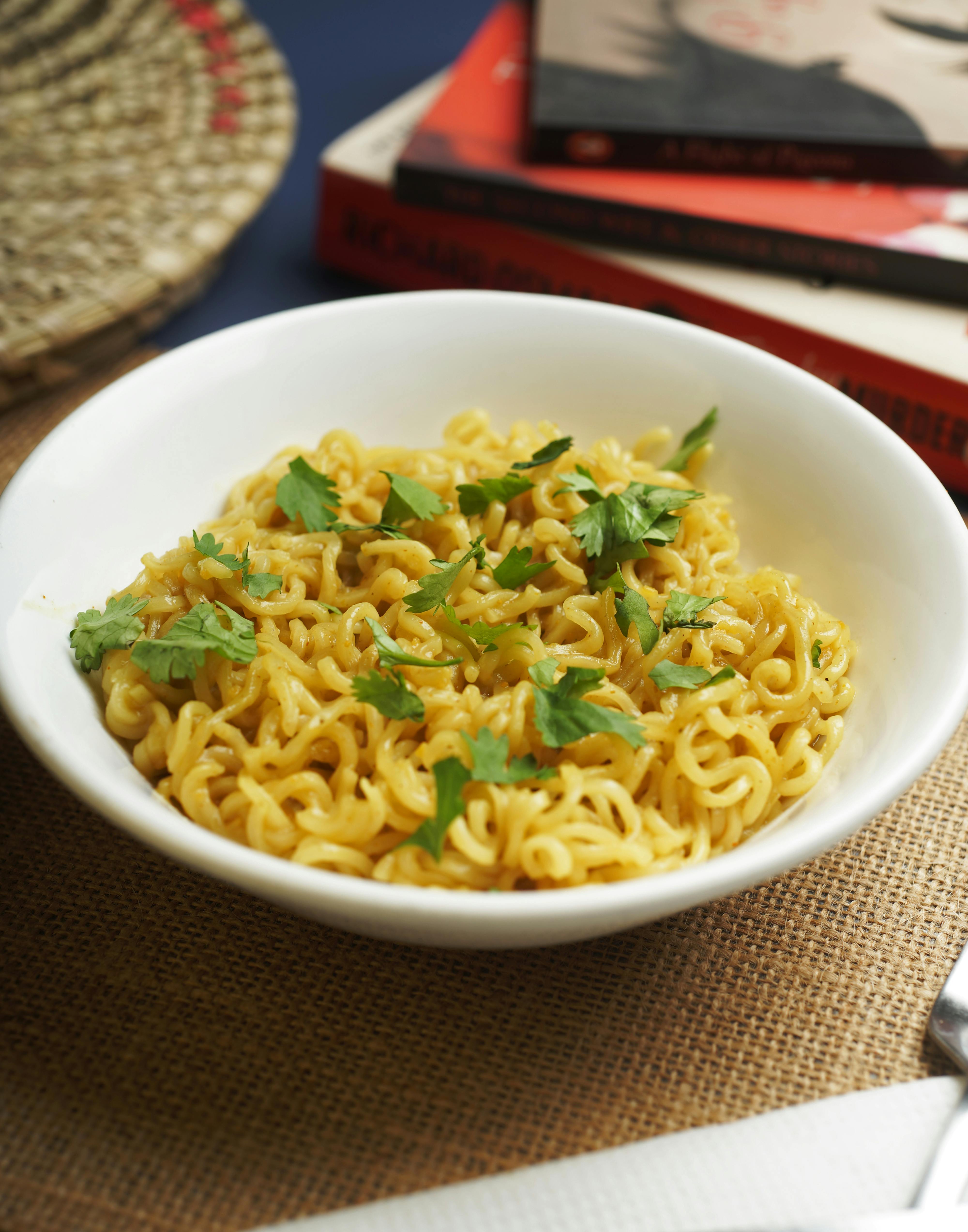 A bowl of seasoned noodles garnished with cilantro, perfect for a quick meal.