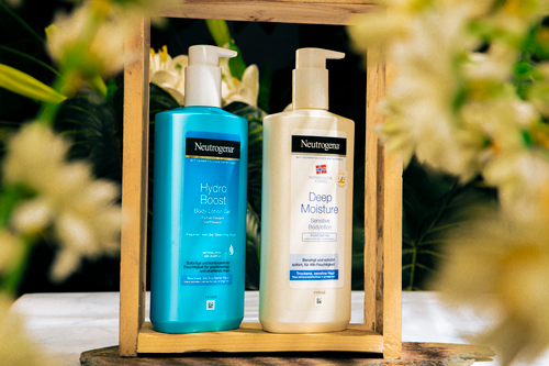 Free Neutrogena Hydro Boost and Deep Moisture lotions in a floral wooden frame. Stock Photo