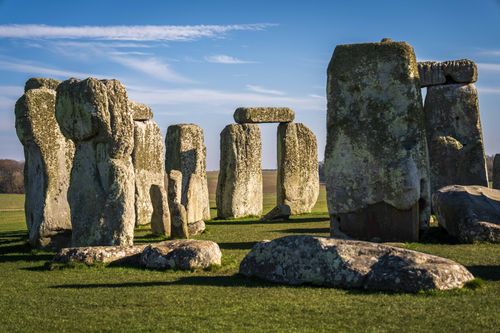 Free Iconic view of Stonehenge under a clear blue sky, showcasing ancient stone formations on a sunny day. Stock Photo