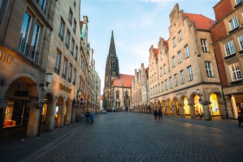 Free Picturesque street view in Münster, Germany showcasing a prominent Gothic church and historic buildings. Stock Photo