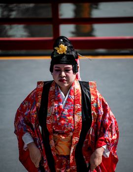 Person in traditional Japanese attire with a serene expression in an outdoor setting. Captivating cultural scene in Buenos Aires.
