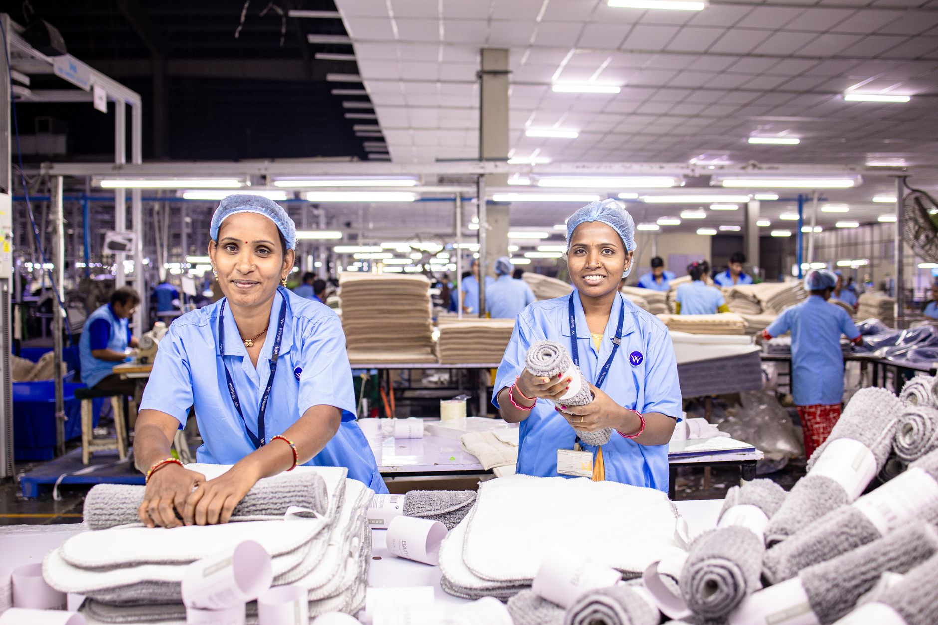Two female textile workers sorting materials in a factory.
