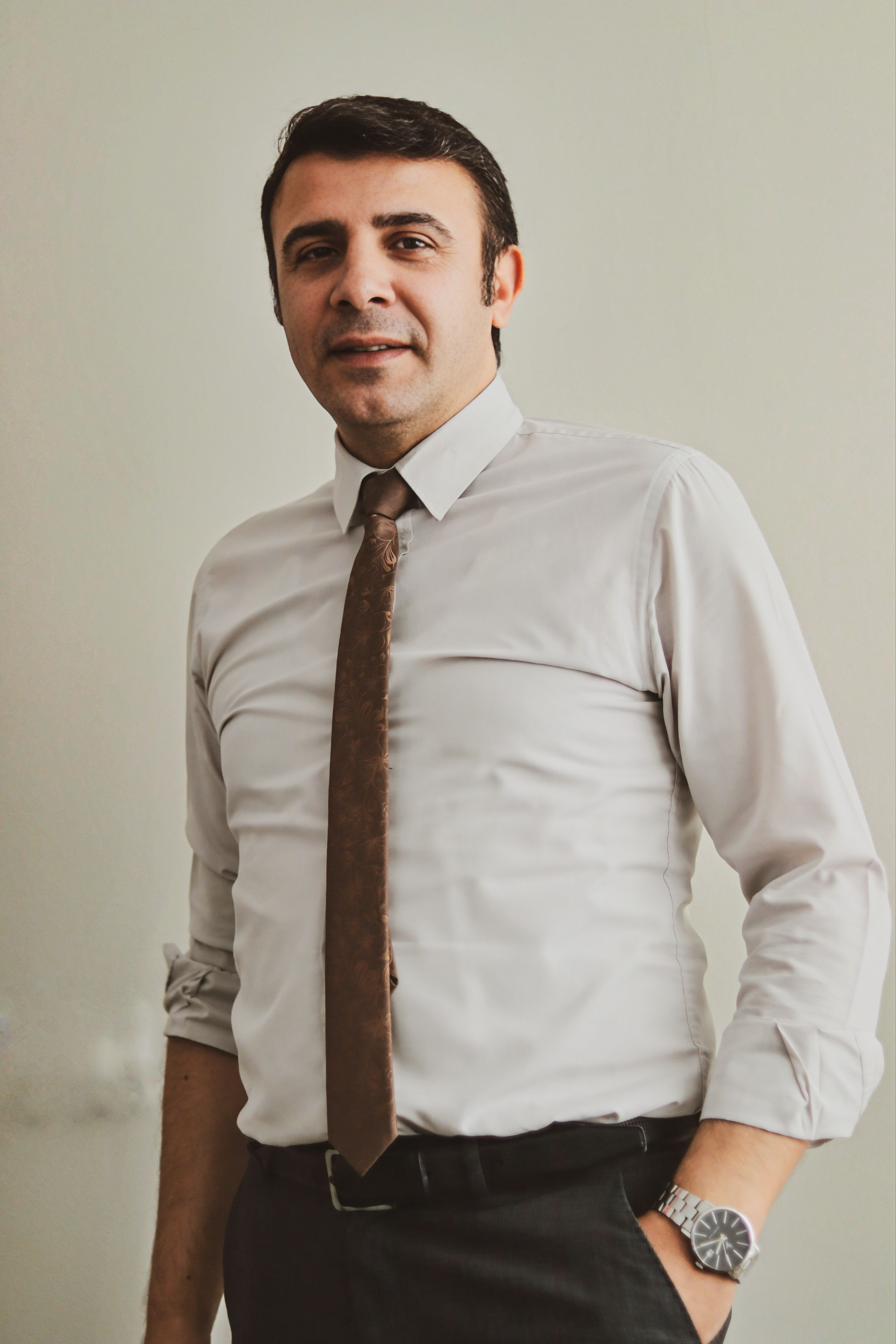 Man in formal attire standing confidently, exemplifying business professionalism in an indoor setting.