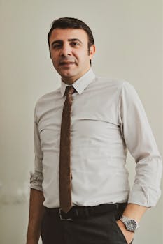 Man in formal attire standing confidently, exemplifying business professionalism in an indoor setting.