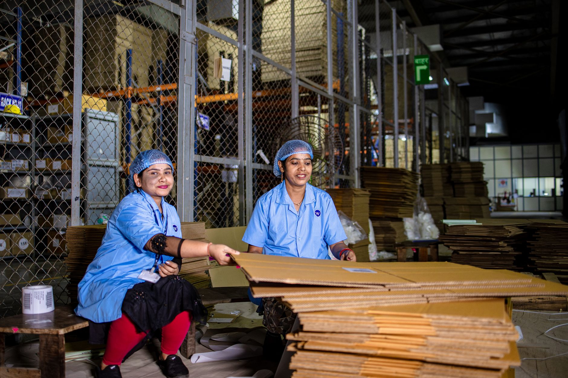 warehouse staff packing fragile products with custom fit cardboard boxes and bubble wrap, e-commerce fulfillment