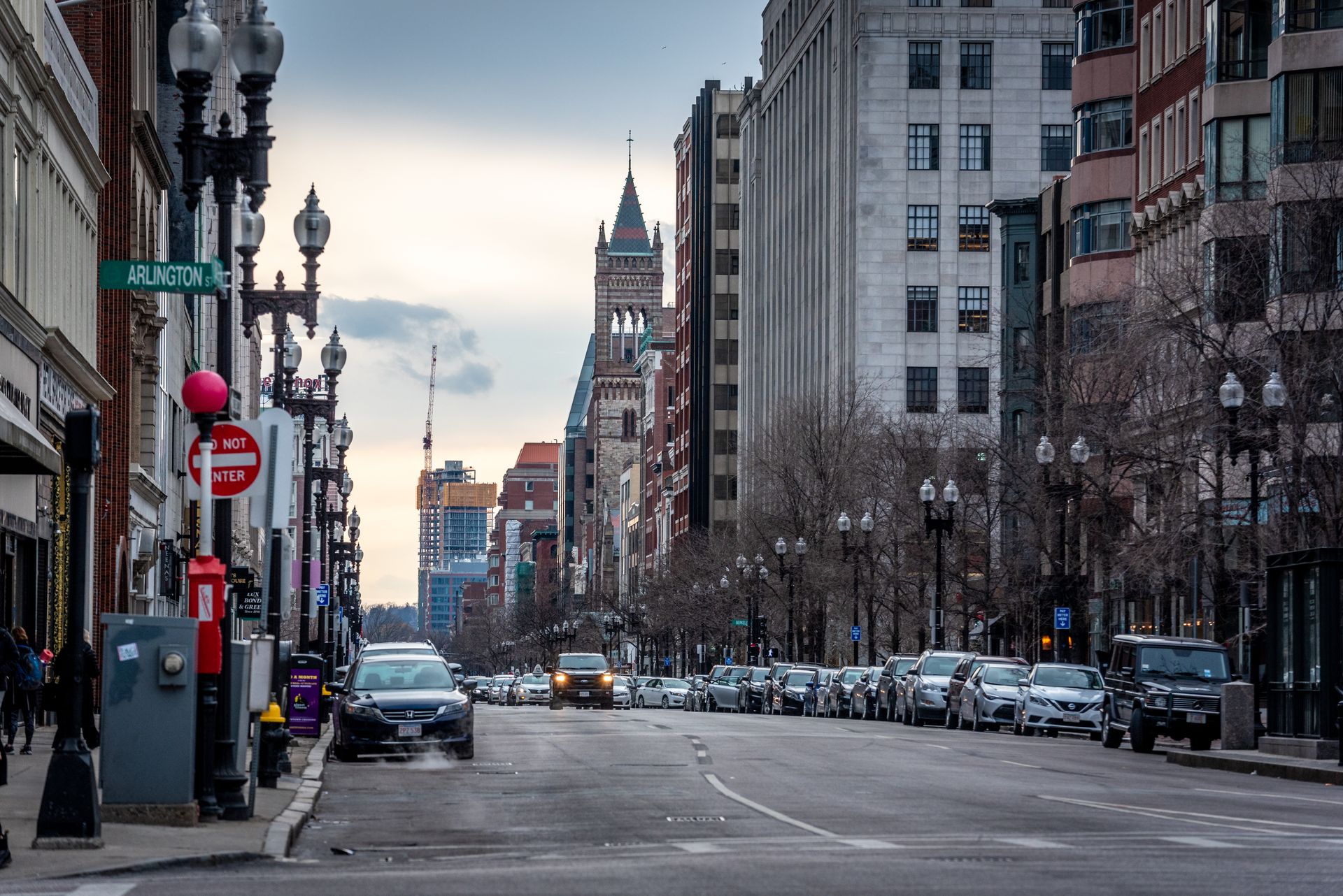 Arlington Street in Back Bay, Boston, with historic Trinity Church and modern buildings lining the street on a clear day