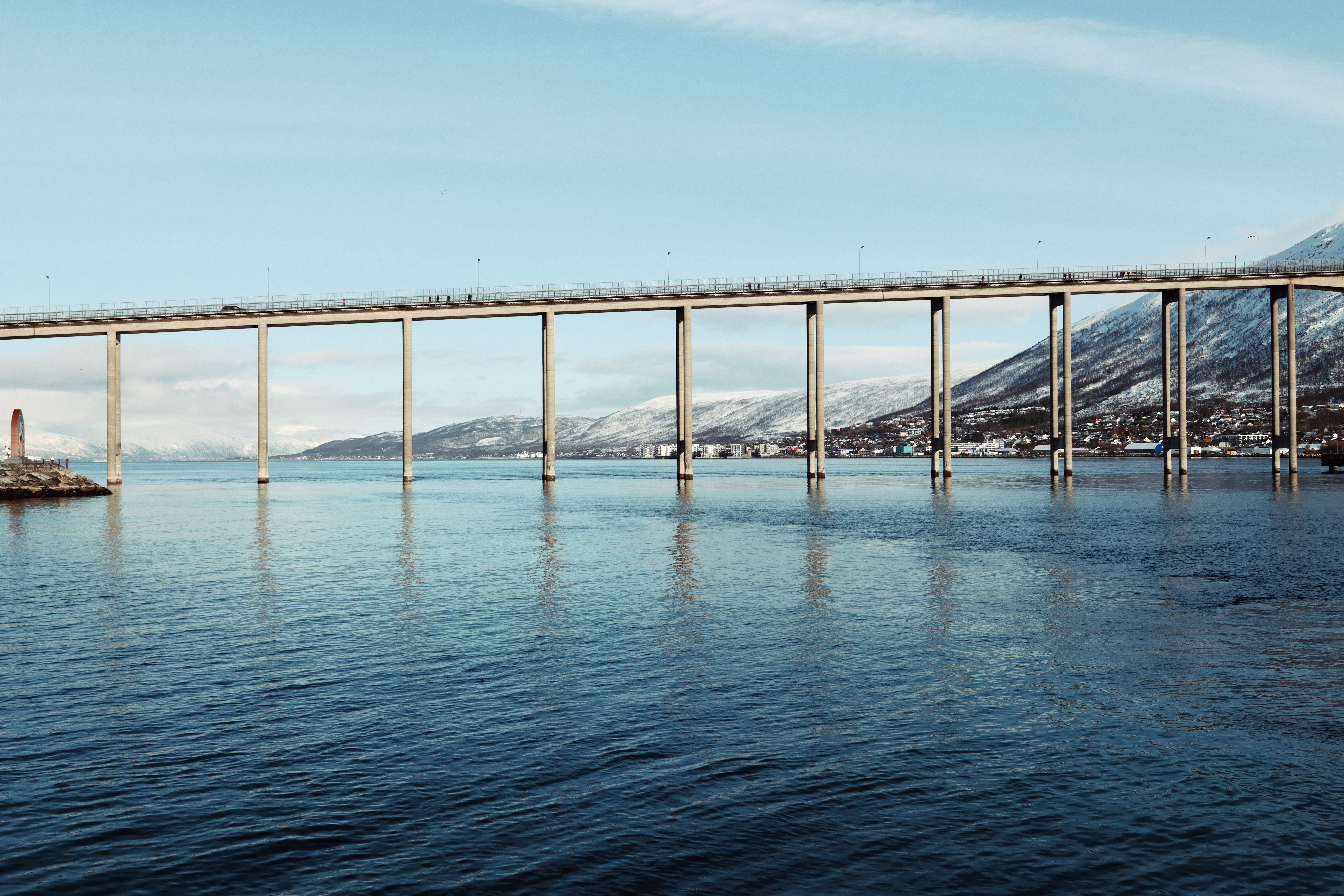 A breathtaking view of the Tromsø Bridge over calm Arctic waters in Norway.