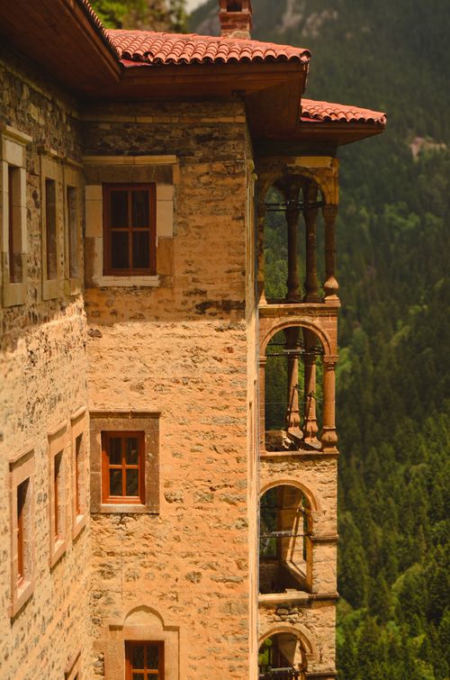 Free A historic stone structure with arched windows and forest backdrop, capturing rustic charm. Stock Photo