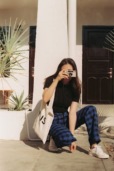 Fashionable young woman posing with a camera in Phan Thiết, capturing a youthful and stylish vibe.