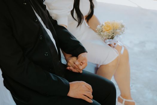 Close-up of a couple holding hands at their wedding ceremony, conveying love and commitment.