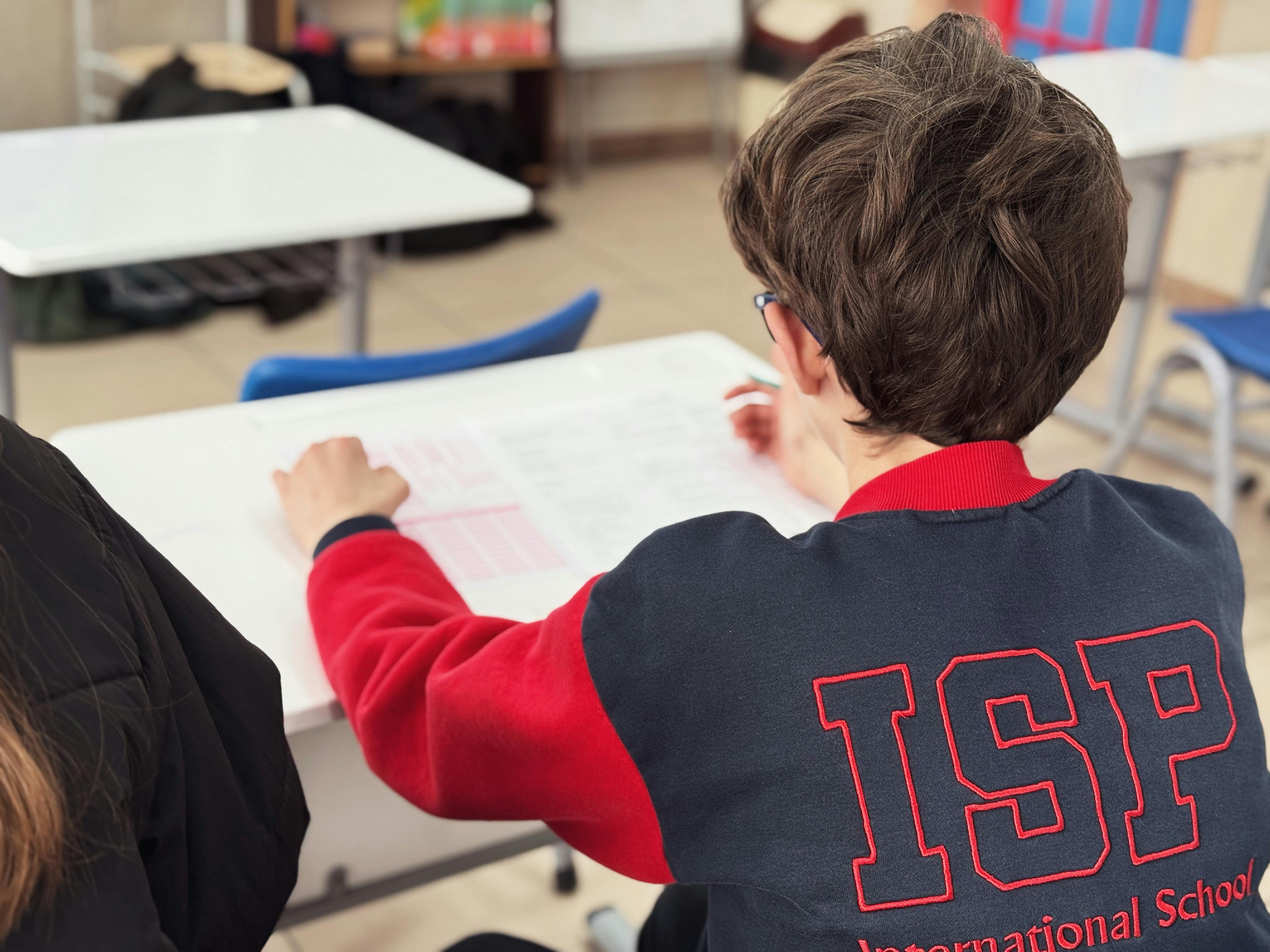 A student engaged in learning at an international school desk.