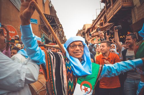 Free Joyful street festival in Cairo showcasing Algerian cultural dance and music. Stock Photo
