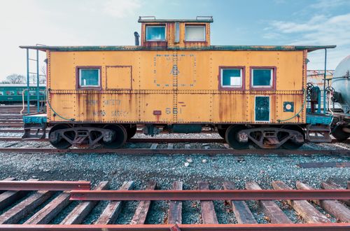Free Rustic yellow caboose on train tracks at Danbury Railway Museum in Connecticut, USA. Stock Photo
