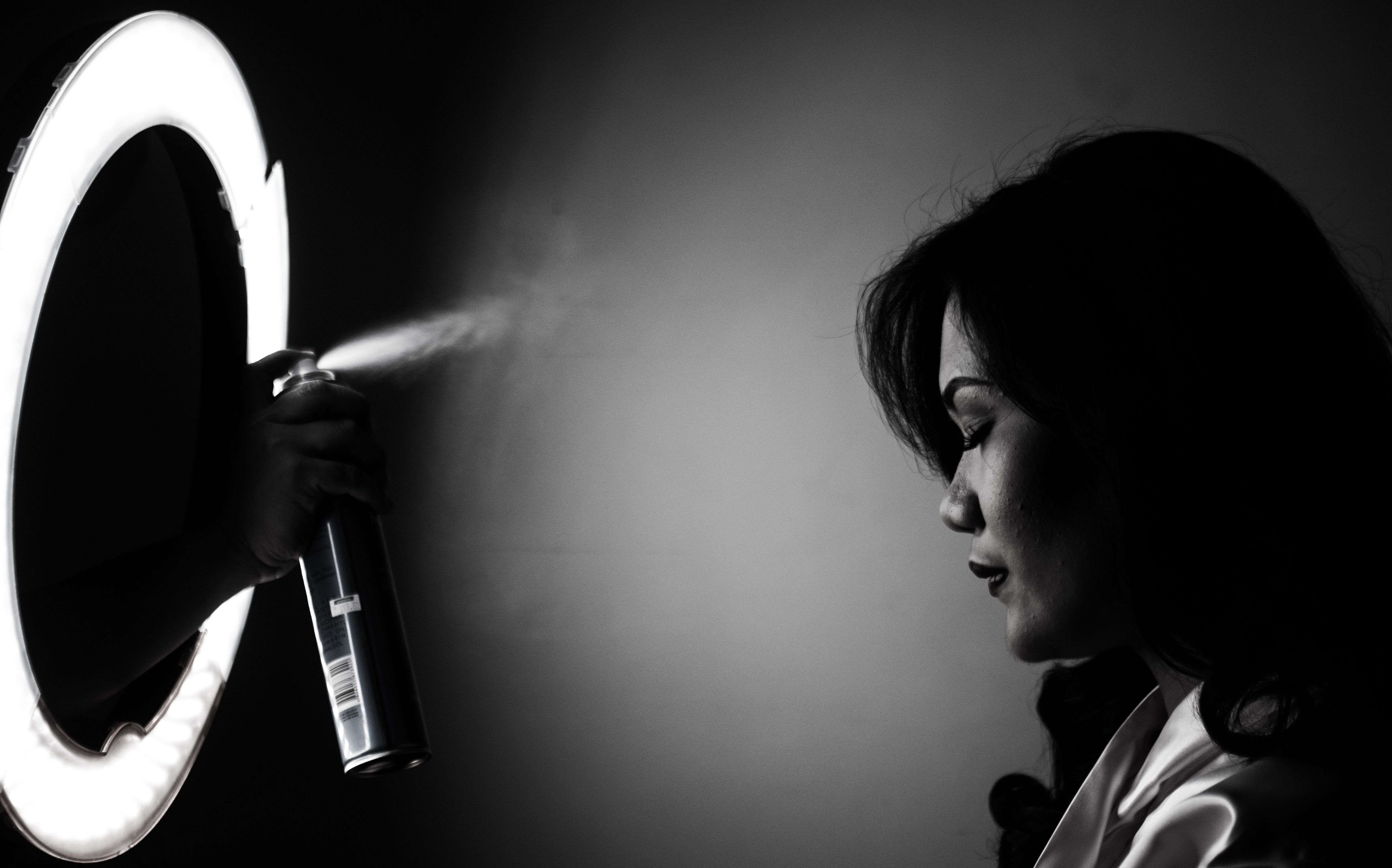 Stylish black and white portrait of a woman with dramatic lighting and spray effect.