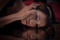 在空灵的反思场景中，捕捉到一位化着艺术妆容的女人的迷人肖像