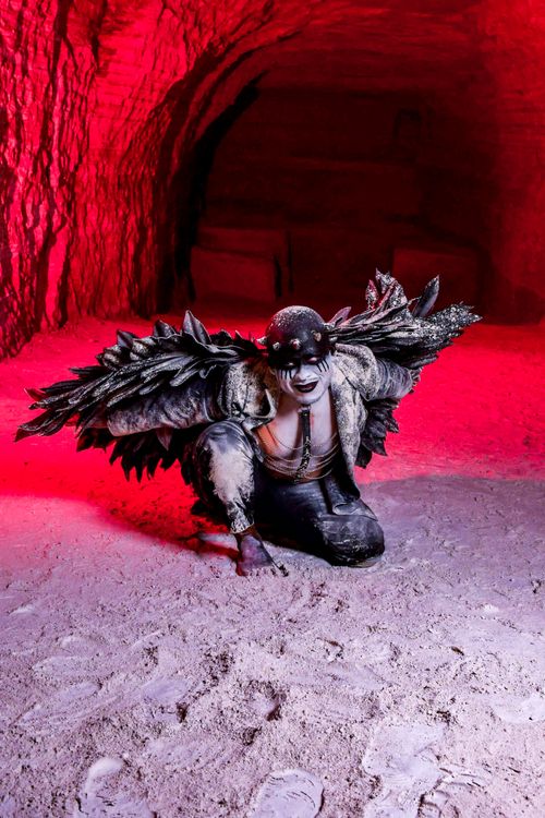 Free Fantasy-themed image of a mythical creature with wings in a cave under dramatic red lighting. Stock Photo