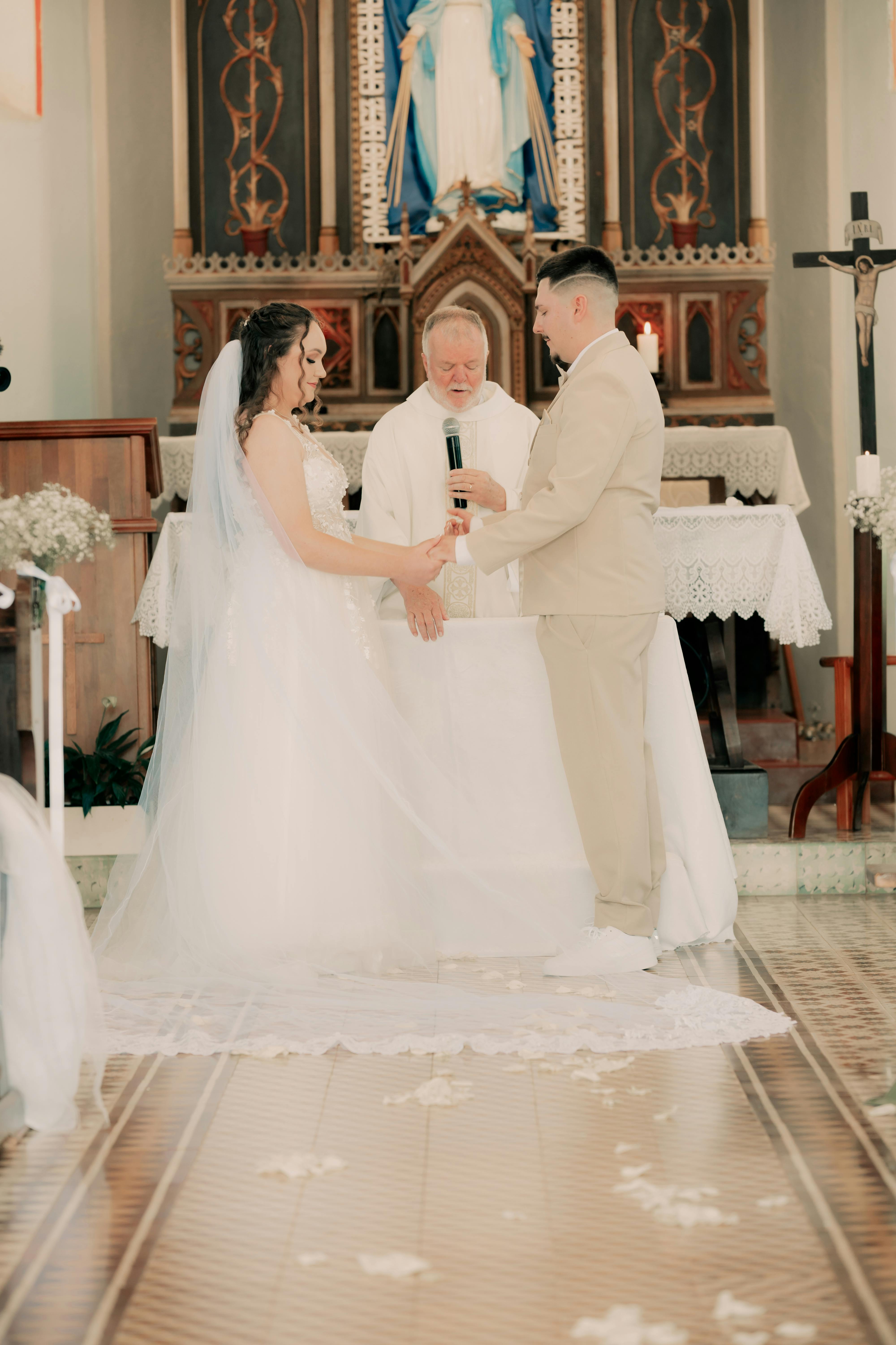 Bride and groom exchanging vows during a wedding ceremony inside a church.